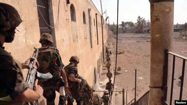 Forces loyal to Syria's President Bashar al-Assad are seen at Hanano barracks in Aleppo city October 7, 2012, after clashes between Free Syrian Army fighters and regime forces.