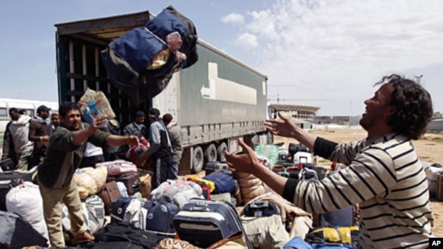 An evacuee reaches out for his luggage at the Libyan Red Crescent camp in Benghazi Apr 16 2011