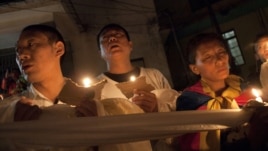 Tibetan exiles hold ceremonial scarves tied together as they participate in a candlelit vigil after reports of another self-immolation in Tibet, in Dharmsala, India, Oct. 5, 2012.