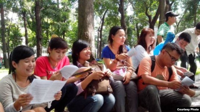 Blogger Hoàng Vi (trái) và các nhà hoạt động trẻ thảo luận về bản Tuyên ngôn Nhân quyền tại một công viên ở Sài Gòn. (Ảnh: Dan Lam Bao).