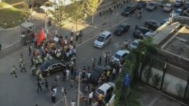 Security officers surround a car carrying U.S. ambassador Gary Locke after anti-Japan demonstrators tried to block the car outside the U.S. embassy in Beijing, September 18, 2012.