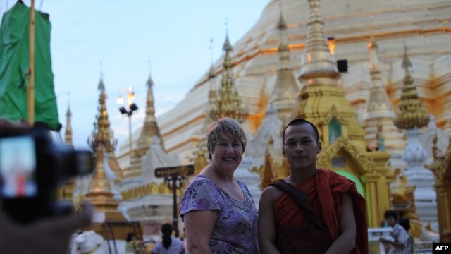 Một du khách chụp ảnh với một tu sĩ Phật giáo tại chùa Shwedagon ở Rangoon, Miến Điện