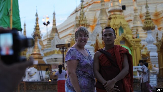 Khách du lịch chụp hình với một tu sĩ Phật giáo tại chùa Shwedagon ở Yangon.