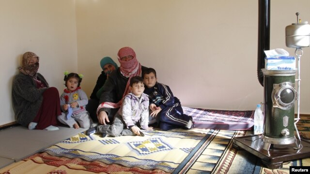 Syrian refugees, who fled the violence in the Syrian town of Qusair, sit at a temporary home, in the hillside town of Arsal in Lebanon's Bekaa Valley, March 5, 2012.