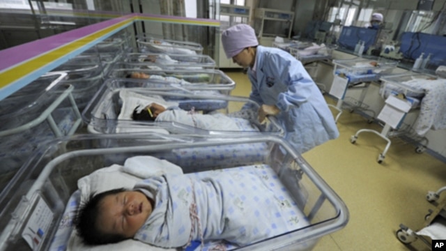 A nurse takes care of newborn babies at a hospital in Hefei, Anhui province April 21, 2011.