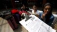 FILE - A Colombian health worker gives travellers information on how to prevent the spread of the Zika virus, at the main bus terminal in Bogota, Colombia, Jan. 31, 2016.