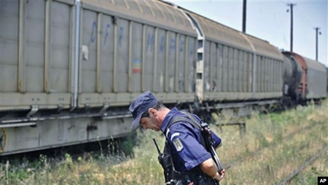A Romanian gendarme stands next to a freight train that was transporting 64 Romanian-produced missile warheads, which authorities say have been stolen, in Giurgiu, southern Romania, July 17, 2011