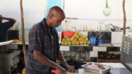 In this photo taken, Tuesday May, 22, 2012 Ahmed Jama chops meat and vegetable at one of his restaurants in Mogadishu, Somalia.