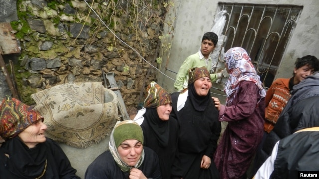 Relatives mourn Ikrama Abkour, whom activists say was killed in a Syrian Air Force missile attack, near Homs, Dec. 21, 2012.