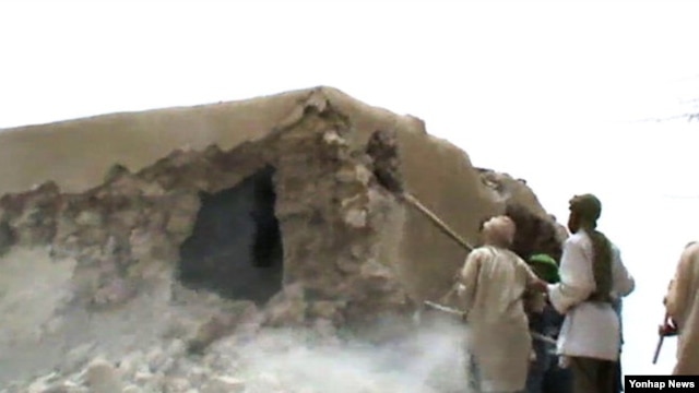 Des islamistes détruisant un monument dans Tombouctou