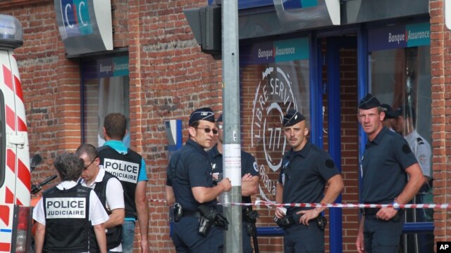 Police officers take positions in front the CIC bank where a man held hostages, in the southern French city of Toulouse, June 20, 2012.