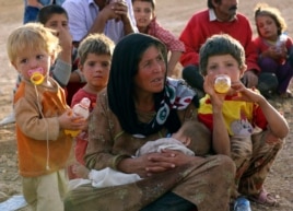 Một bà mẹ tỵ nạn Syria cùng con nghỉ chân tại cửa biên giới gần Suruc, Thổ Nhĩ Kỳ.