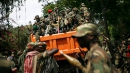 FILE - M23 rebels sit in a vehicle as they withdraw from the eastern Congo town of Goma, Dec. 1, 2012..