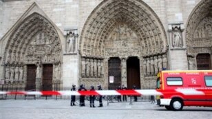 Police officers stand guard in front of Notre Dame Cathedral, in Paris, Tuesday, May 21, 2013. Notre Dame has been evacuated after a man committed suicide in the 850-year-old monument and tourist attraction. (AP Photo/Thibault Camus)