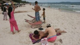 A Cambodian woman gives massage to a tourist on the beach of Sihanoukville, some 185 kilometers (115 miles)  southwest of Phnom Penh, file photo. 