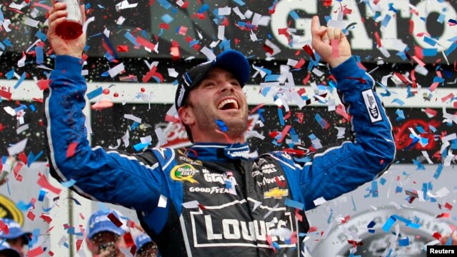 El piloto Jimmie Johnson celebra el triunfo al ganar la serie Copa Sprint de NASCAR en la pista internacional de carreras en Daytona, Florida.