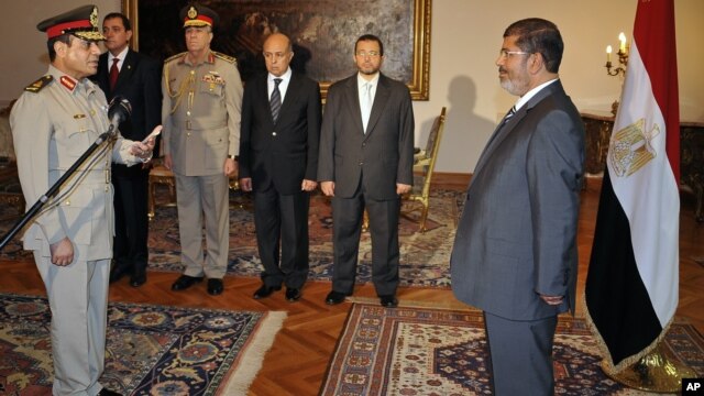 Egyptian President Mohammed Morsi swears in newly-appointed Minister of Defense, Lt. Gen. Abdel-Fattah el-Sissi, in Cairo, Egypt, Sunday, Aug. 12, 2012.