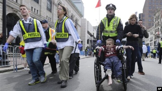 Cảnh sát và nhân viên y tế &dstrok;ưa người bị thương ra khỏi hiện trường sau vụ nổ bom ở Boston, ngày 15/4/2013. 