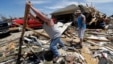 Chad Allcox, left, helps his friend Kevin McElvany, right, the home owner, clear debris away from his destroyed home from Monday's tornado, Moore, Oklahoma, May 22, 2013. 