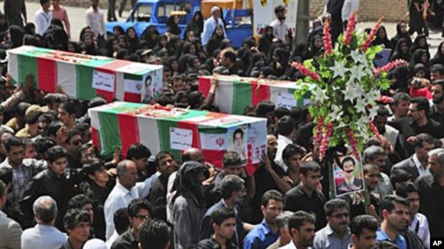 During a funeral ceremony, people carry flag-draped coffins of victims of two bomb blasts in Zahedan,  southeast of Tehran, claimed by the Sunni group, Jundallah, 17 Jul 2010