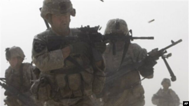 A U.S. soldier returns fire as others run for cover during a firefight with insurgents in the Badula Qulp area, West of Lashkar Gah  in Helmand province, southern Afghanistan (FILE).