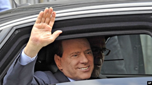 Italy Prime Minister Silvio Berlusconi waves as he leaves the Justice Palace in Milan, Italy, September 19, 2011.