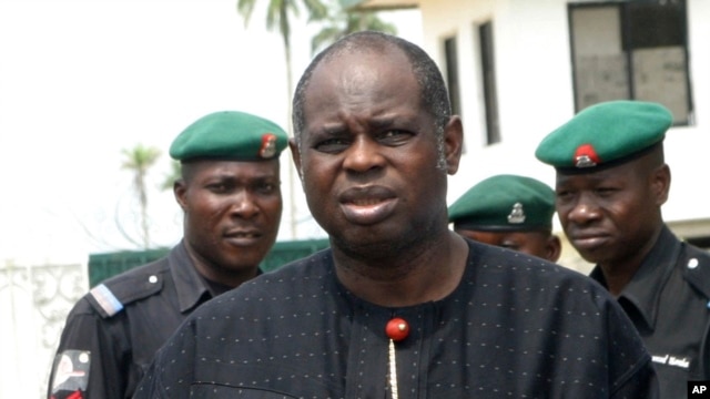 Bayelsa State Governor Diepreye Alamieyeseigha stands outside his house guarded by policemen in Yenagoa, Nigeria, in this photo dated November 27, 2005.