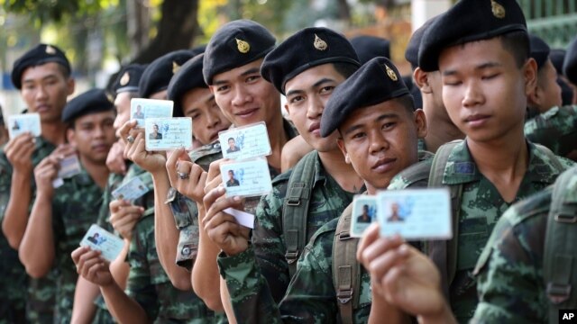 ទាហាន​ថៃ​បង្ហាញ​អត្តសញ្ញាណប័ណ្ណ​ខណៈ​ពួក​គេ​តម្រង់​ជួរ​ដើម្បី​បោះឆ្នោត​នៅ​ក្នុង​ទី​ក្រុង​បាងកក កាល​ពី​ថ្ងៃ​ទី​២​ កុម្ភៈ ឆ្នាំ​២០១៤។