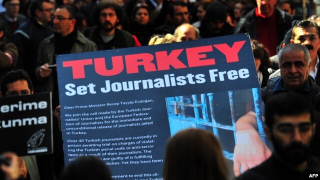 Turkish journalists carry a large sign displaying a letter to Turkish Prime Minister Recep Tayyip Erdogan that calls for the release of jailed journalists, during a demonstration on Istiklal Avenue in Istanbul, on March 13, 2011.