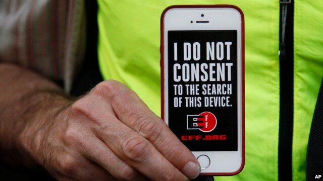 Một người đàn ông cầm chiếc iPhone của mình trong cuộc biểu tình ủng hộ bảo mật dữ liệu bên ngoài một cửa hàng Apple ở San Francisco, California, ngày 23 tháng 2 năm 2016.