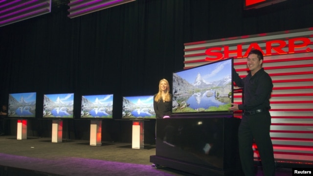 Models show a ICC Purios Ultra HD television at a Sharp news conference during the Consumer Electronics Show (CES) in Las Vegas January 7, 2013. Seen in the background are new Aquos 8-Series televisions and a 90-inch LED Smart 3D TV (far left). Sharp 