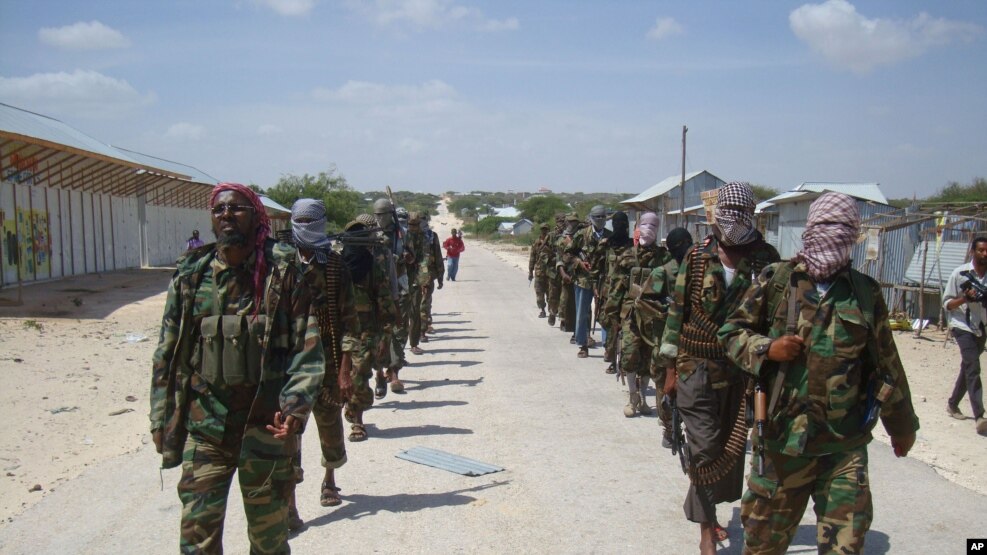  FILE - Members of Somalia's al-Shabab militant group patrol on the outskirts of Mogadishu, March, 5, 2012. Citing senior U.S. officials, The New York Times reported Monday the administration has deemed al-Shabab to be part of the armed conflict that Congress authorized against the perpetrators of the September 11, 2001 attacks.