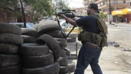A Sunni gunman fires his weapon during clashes on Syria Street which divided the areas between Sunnis and Alawites, in the northern port city of Tripoli, Lebanon, May 13, 2012. 