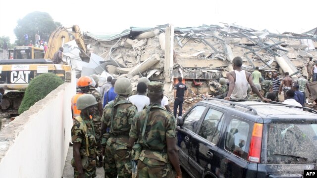 People look at an excavator clearing the rubble on the scene of a six-story shopping center that collapsed in Accra, November 7, 2012.