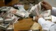 An employee counts money at a bank in Cairo, Egypt, Sept. 4, 2014.  