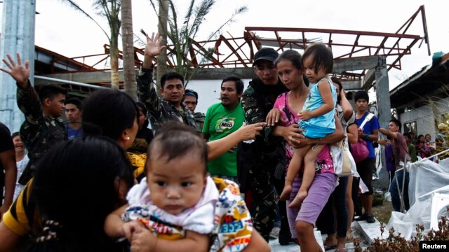Binh sĩ giúp cư dân lên máy bay vận tải C130 của Mỹ, rời thành phố Tacloban bị bão tàn phá, ngày 11/11/2013.  