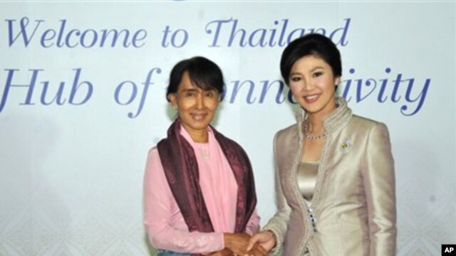 Burma's Aung San Suu Kyi, left, shakes hands with Thailand's Prime Minister Yingluck Shinawatra in this picture from the Thai government. 