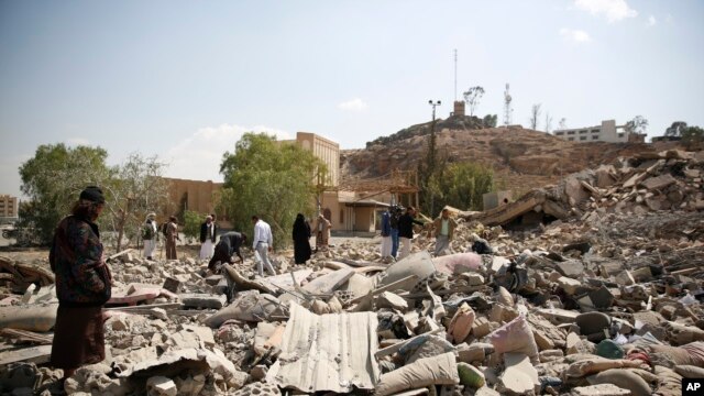 People gather as they inspect Youth and Sports Ministry's building destroyed by Saudi-led airstrikes in Sana'a, Yemen, Jan. 17, 2016. (