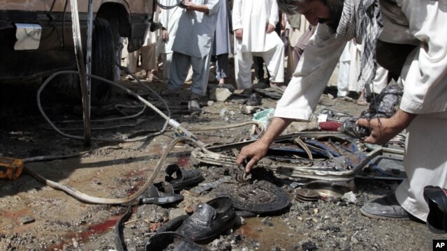 A man collects parts of a damaged bus which was hit by a remote control bomb on the outskirts of Kabul, Afghanistan, August 7, 2012.