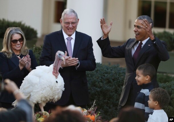 President Barack Obama, with his nephews Aaron Robinson and Austin Robinson and National Turkey Federation Chairman John Reicks, pardons the National Thanksgiving Turkey, Tot, during a ceremony in the Rose Garden of the White House in Washington, Nov. 23,