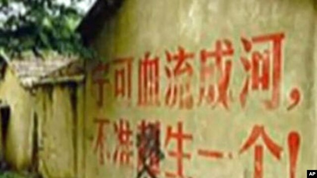 女权无国界组织提供照片：墙上标语说：宁愿血流成河也不准多生一个.