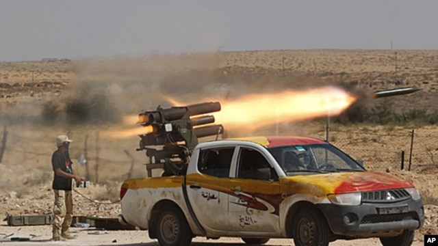 An anti-Gaddafi fighter fires a multiple-rocket launcher near Sirte, the hometown of deposed leader Moammar Gaddafi, September 17, 2011.