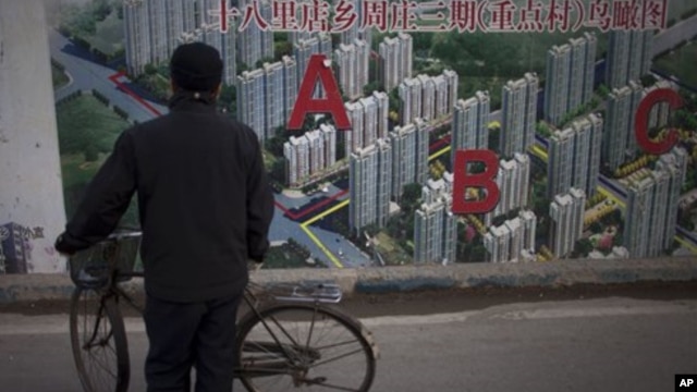 Seorang warga tengah mengamati gambar peta proyek perumahan yang dipajang di pembatas wilayah sebuah konstruksi di Beijing, TIongkok, 17 Januari 2013. (AP Photo/Alexander F. Yuan). Laju pertumbuhan ekonomi Tiongkok dilaporkan meningkat menjadi 7,9 persen pada kuartal ke-4 tahun 2012 yang lalu.