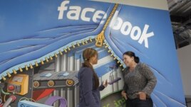 Two workers inside of Facebook headquarters in Menlo Park, Calif
