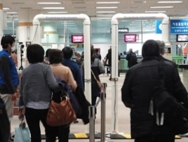 Passengers from Japan passing through a radiation screening point at Gimpo International Airport, Sunday, 27 March 2011