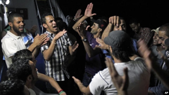 Libyans chant anti-Moammar Gadhafi slogans aboard the Azzurra Line on their way from Benghazi to Misratah, Libya. Bombing continued early Friday as three fresh strikes sent plumes of smoke over Tripoli, June 10, 2011