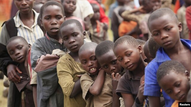 Refugee children, displaced by continued fighting in north Kivu province in the Democratic Republic of Congo, queue for food in the Nyakabande refugee transit camp in Kisoro town, July 13, 2012.