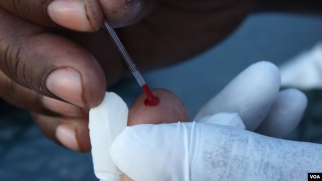 Blood is taken from someone’s finger to test it for HIV at Bulungula, South Africa  (D. Taylor/VOA)