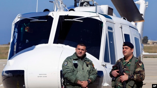 Lebanese army soldiers stand guard in front of a military Huey II helicopter during a ceremony at the Rafik Hariri International Airport in Beirut, Lebanon, March 31, 2016.