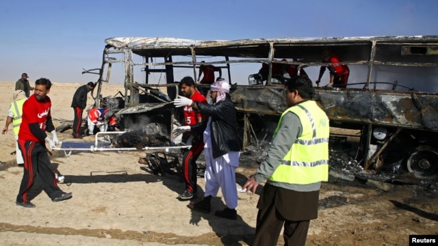 Para petugas mengangkat sisa-sisa jenazah para peziarah Syiah yang terbakar dari dalam bus di Quetta, Pakistan (30/12). Iring-iringan bis para peziarah Syiah ke Iran  menjadi target bom yang diledakkan dari jarak jauh. Dilaporkan 20 orang tewas dan sedikitnya 24 terluka dalam insiden ini.